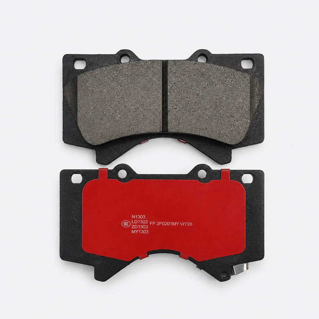 Brake pad friction surface and red backing plate, showing the groove, mounting holes and hardware